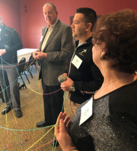 Board members create a web with brightly colored yarn
