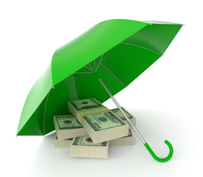 A bright green umbrella sits open on the ground over a stack of cash