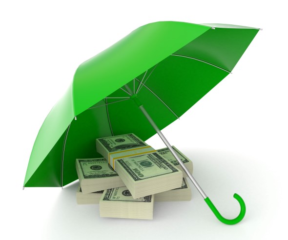 A bright green umbrella sits open on the ground over a stack of cash